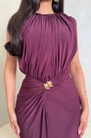 فستان بنفسجي بتصميم كسرات وتفصيل ذهبي عند الخصر