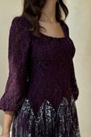 فستان بنفسجي مطرز بتفاصيل لامعة وأكمام منفوخة