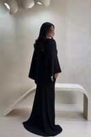 فستان أسود بتفاصيل خضراء لامعة بتصميم فاخر