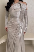 فستان فضي لامع بتصميم لف فاخر وأكتاف مكشوفة