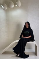 فستان أسود بتفاصيل خضراء لامعة بتصميم فاخر