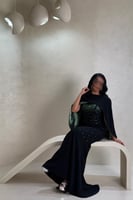 فستان أسود بتفاصيل خضراء لامعة بتصميم فاخر