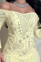 فستان أصفر بتطريز كريستالي وقماش انسيابي فخم