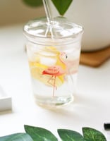 كوب زجاجي بغطاء مع مصاص برسم طائر لفلامينغو .