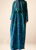 شرشف صلاة لف مرد منقوش ازرق واخضر و الطرحة مثبتة.