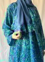 شرشف صلاة لف مرد منقوش ازرق واخضر و الطرحة مثبتة.