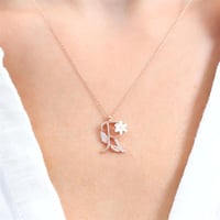 سلسال فضة راقي مطلي بالذهب، يحمل حرف (R) مرصّع بفص...