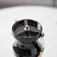 مطحنة قهوة يدوية باللون الاسود والبني