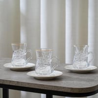 طقم بيالات شاي مع صحون بتصميم مميز لون شفاف وابيض...