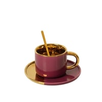 فنجان قهوة بتصميم عصري مع صحن لون احمر وذهبي