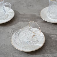 طقم بيالات شاي مع صحون بتصميم مميز لون شفاف وابيض...