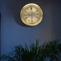 ساعة حائط بإطار مزخرف باللون الذهبي بأرقام لاتينية...