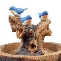 نافورة علي شكل طاولة خشبية و مزينة بجذع شجرة و عصا...