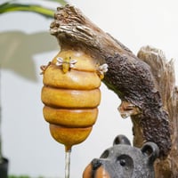 نافورة مياه بتصميم جذع شجرة و مزينة بخلية نحل و دب...