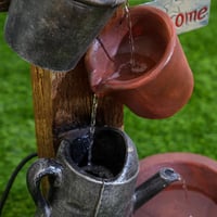 نافورة مياه علي شكل لوح خشبي مثبت عليها اباريق مقا...