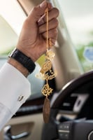 تعليقة سياره يد ماسكه ورده بكسرة العود بالاسم