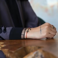 سوارة بشكل المرساة وخيط نحيف باللون البرتقالي من ف...