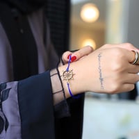 سوارة بشكل دفة السفينه وخيط نحيف باللون الازرق من...