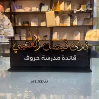 استاند اسم فاخر باللون الأسود مع خط ذهبي أنيق