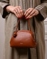 شنطة نسائية كقطعة فنية من الجلد بلون بني