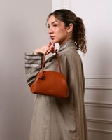 شنطة نسائية كقطعة فنية من الجلد بلون بني