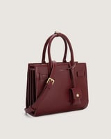 شنطة نسائية متوسطة الحجم بلون عودي.