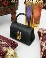 شنطة أنيقة من الجلد بحجم صغير بلون أسود