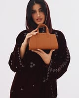 شنطة نسائية بمقاس متوسط بلون بني.