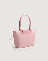 ‎ شنطة نسائية بحجم متوسط بلون وردي.