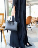 شنطة نسائية بتصميم عملي بلون أسود.