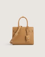 شنطة نسائية متوسطة الحجم بلون بني.