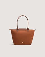 ‎ شنطة نسائية بحجم متوسط بلون بني.