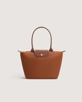 ‎ شنطة نسائية بحجم متوسط بلون بني.