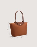 ‎ شنطة نسائية بحجم متوسط بلون بني.