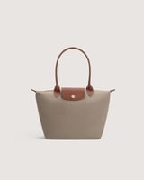 ‎ شنطة نسائية بحجم متوسط بلون رمادي.