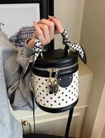 أبيض منقّط بالأسود، مع تفاصيل سوداء ومعدنية ذهبية