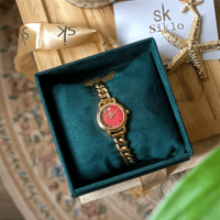 ساعة باللون الذهبي ميناء احمر