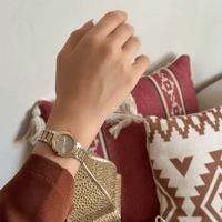 ساعة بإطار ملفت بلون الذهبي فضي ميناء رصاصي مرصع ب...