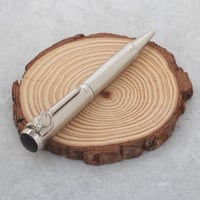 قلم بتصميم سميك باللون الفضي وبملمس ناعم