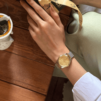 ساعة نسائية بسير حصير ملفت باللون الذهبي والفضي مي...