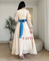 فستان بيج مزين بالؤلؤ وحزام أزرق