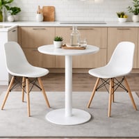 طاولة دائرية بتصميم بسيط وأنيق، بلون أبيض نقي مع ق...