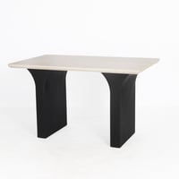 طاولة عصرية بسطح فاتح أنيق وقاعدة سوداء منحنية تعط...