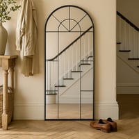 مرآة أنيقة بإطار أسود وقوس علوي، تضيف عمقاً وأناقة...