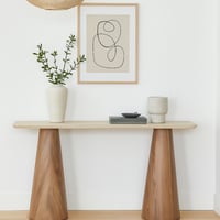 كونسول أنيق بسطح بيج وقاعدة خشبية بشكل مخروطي.