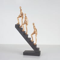 مجسم لثلاثه اشخاص يتحركون لأعلى السلم