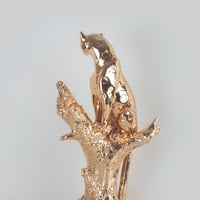 مجسم نمر على جذع شجرة