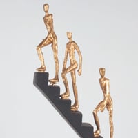 مجسم لثلاثه اشخاص يتحركون لأعلى السلم