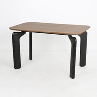 طاولة مودرن بسطح خشبي دافئ وأرجل سوداء منحنية بتصم...