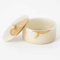 علبة ديكورية أنيقة بغطاء ذهبي بتصميم ورقة فخم.